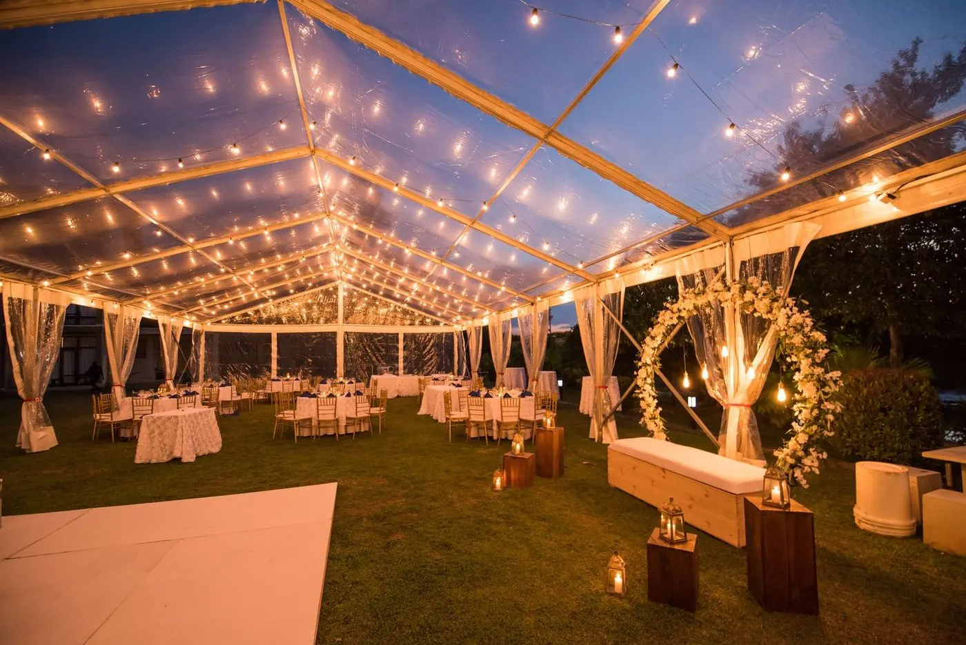 Evening reception under the lit event tent on the farm lawn